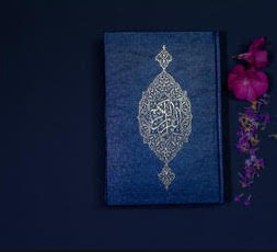 Blue Quran on blue background with pink flowers